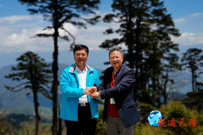 02 在不丹多楚拉山口，美国儒商会会长陈绍恭（右）与中国摄影家朱正明紧紧握手.jpg