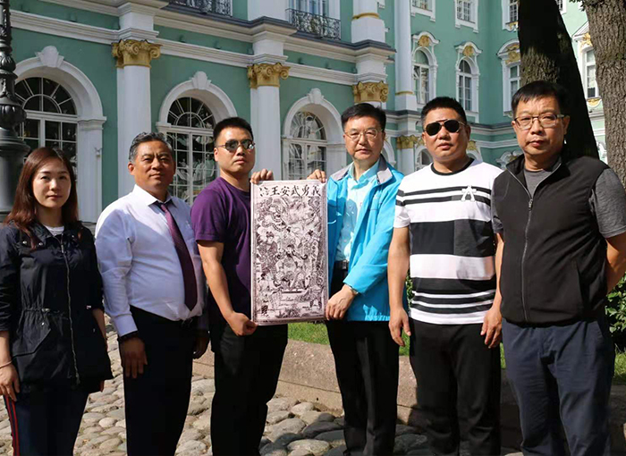 关公文化学者朱正明(右三)、湖北企业家刘松旺(右二)、刘智(右一)、王湘平(左三)、严娟(左)、江苏企业家汪学湘(左二)在圣彼得堡冬宫博物馆展示世界目前最早的关公木版画复制品(李享摄影).jpg