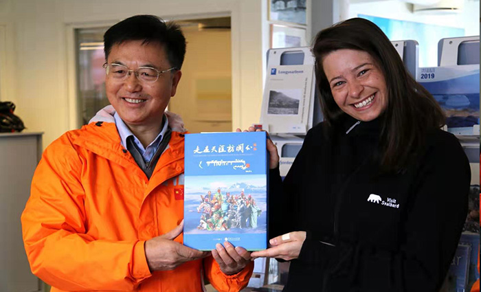 在北极斯瓦尔巴群岛,朱正明向当地政府旅游局官员Tonc Smith-Qvlaud讲述世界关公文化故事,赠送《走遍天涯访关公》新著(李享摄影).jpg