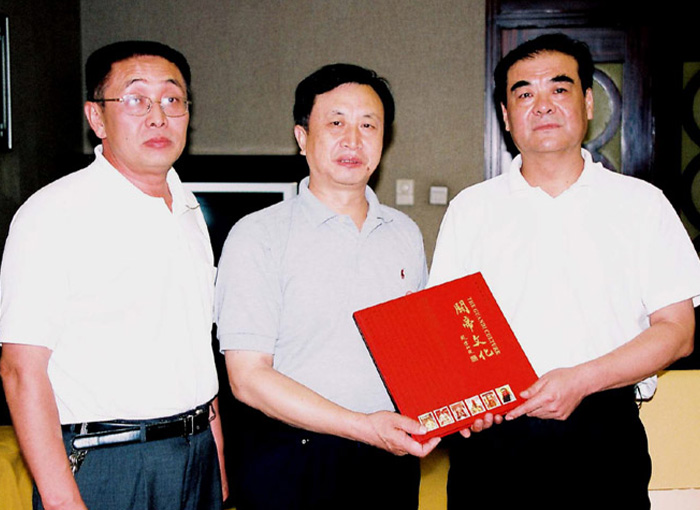 1 湖北省海外联谊会名誉副会长缪启明先生(中)向王大高先生(右)赠送《关帝文化》珍贵邮册.jpg