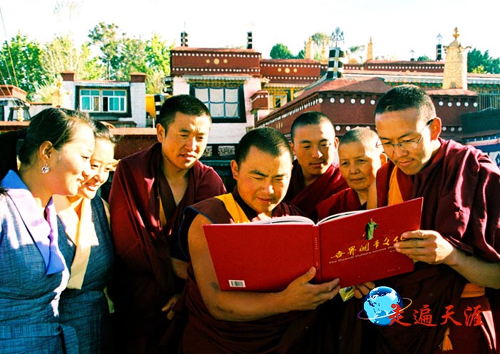 5 拉萨关帝庙喇嘛和西藏大学学生围观《世界关帝文化》画册.jpg