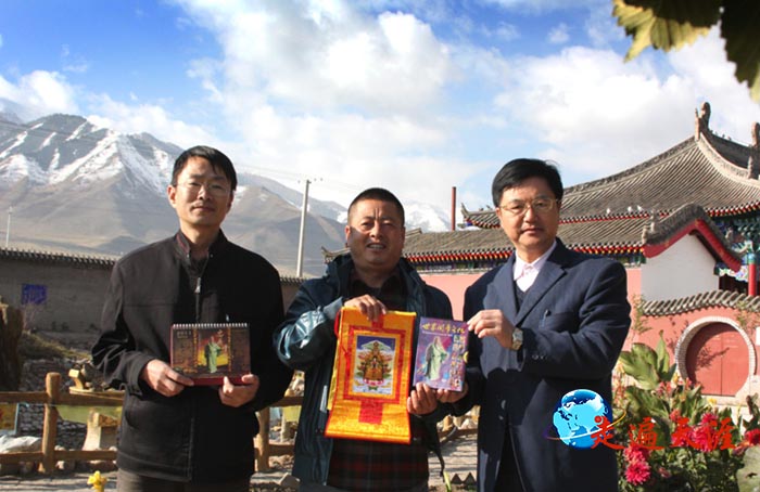 9 在天山脚下的巴里坤县,摄影家朱正明(右)向文物局长蒋晓亮(中)赠送关公唐卡,左为哈密市政府吴江主任.JPG