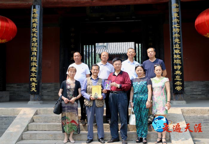 4 在阳泉关王庙山门前,朱正明(中)向大家赠送关帝文化书籍,左二为黄顺荣先生.jpg