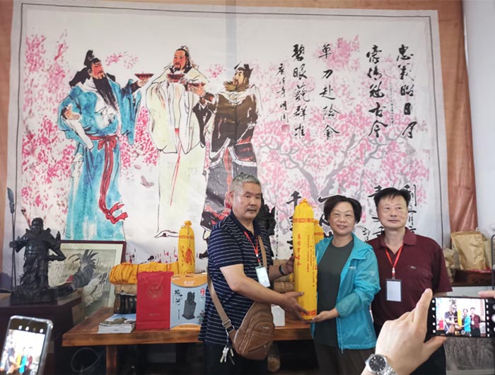 7 河南洛阳关林文物管理处处长李春敏(中)与李学良会长互赠礼品.jpg