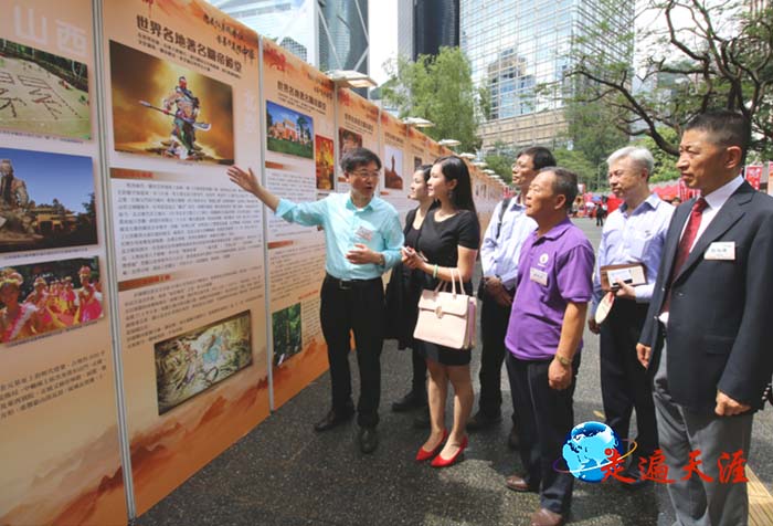 11 香港首届关公节,摄影家朱正明《世界的关公》在港岛遮打花园举办。图为朱正明(左)向新华社记者和嘉宾介绍世界关帝文化风情.JPG