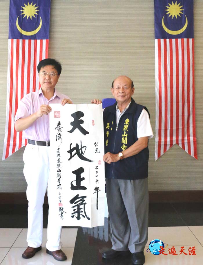 7 在马来西亚,高雄东照山关帝庙堂主吴贵荣向朱正明先生赠送“天地正气”条幅.JPG