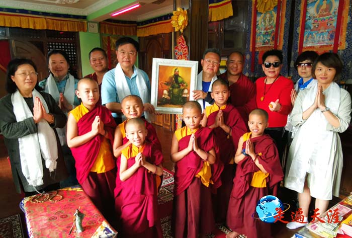 06 在加德满都华严寺,朱正明和爱国侨领陈绍恭向龙奔法师赠送苏英毅油画关公作品.jpg