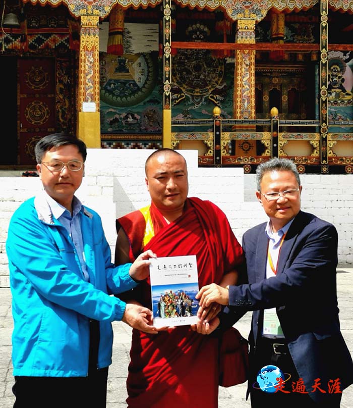 06 在不丹王宫,朱正明向国师特别助理、乌金堪布Khenpo Ugyen tenzin drukdra(中)赠送《走遍天下访关圣》西藏版,右为美国儒商会会长、爱国侨领陈绍恭先生.jpg