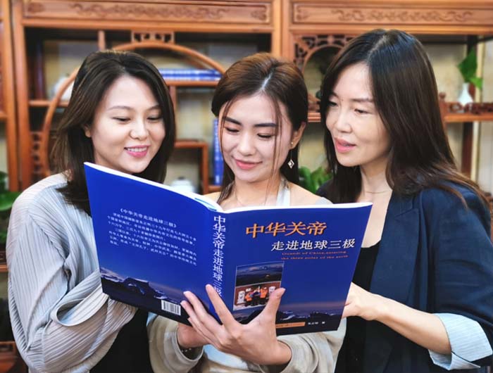 5 右起 津巴布韦企业家杜睿、欧洲湖北商会文化交流部部长杨兵兵、澳大利亚联邦银行慧子正在拜读新著《中华关帝走进地球三极》.jpg