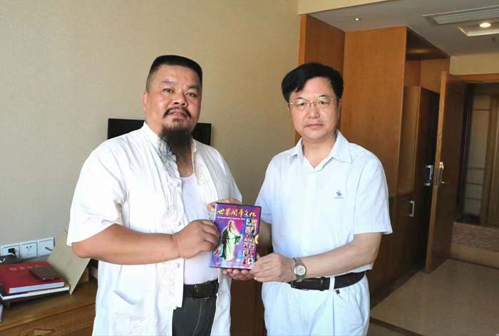 4 文化學著朱正明向畫家無塵先生(左)贈送《世界關帝文化文化》光盤.jpg